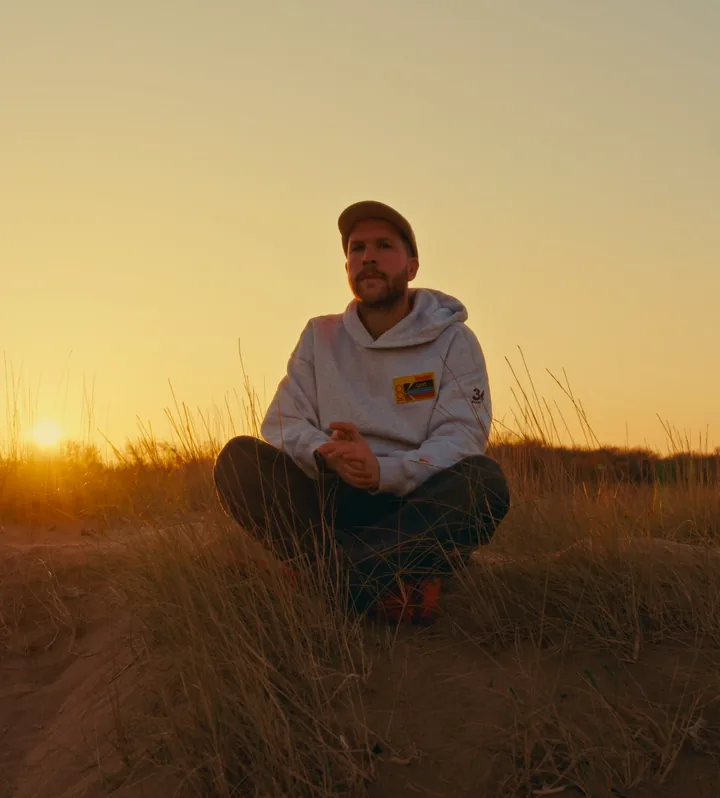 Timo, de maker van Rushwise, in de duinen bij zonsondergang